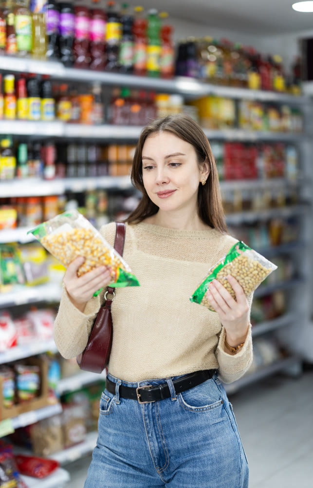 Girl in supermarket search and select product beans