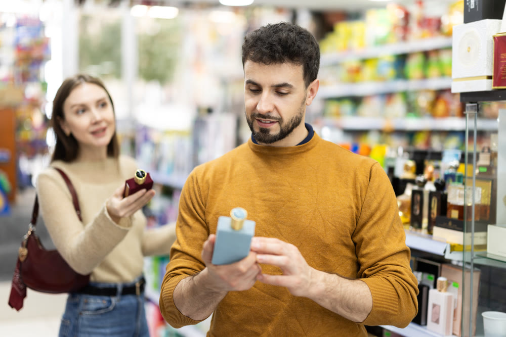 Couple choosing bottle of perfume in perfume shop
