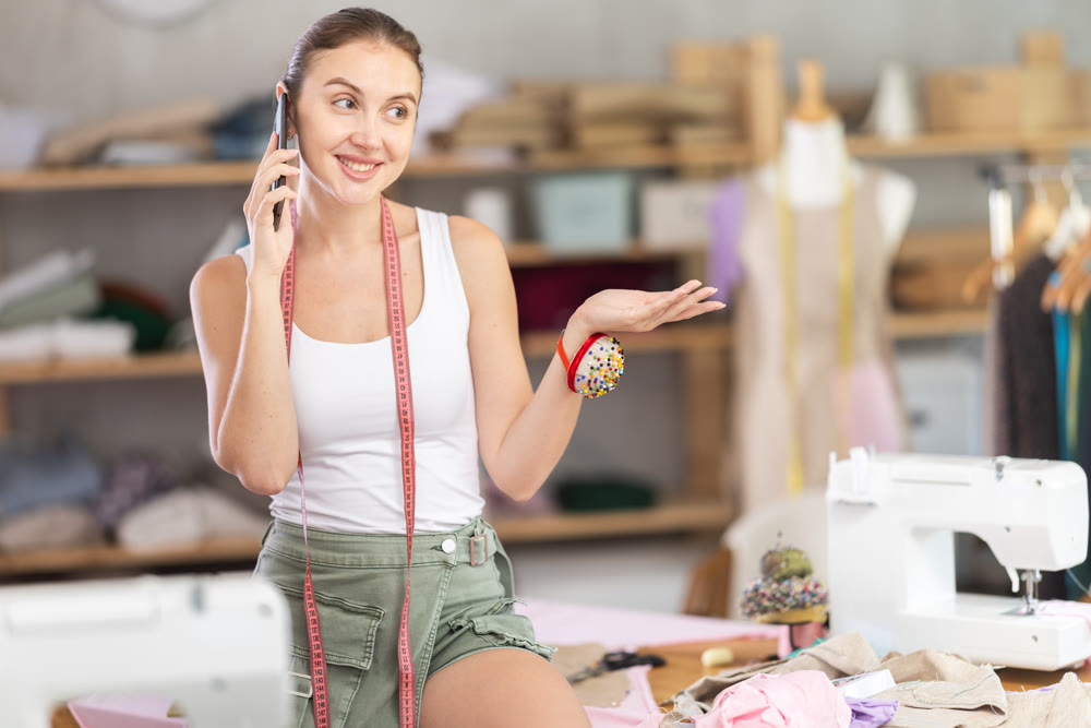 Female fashion designer talking on phone in workshop