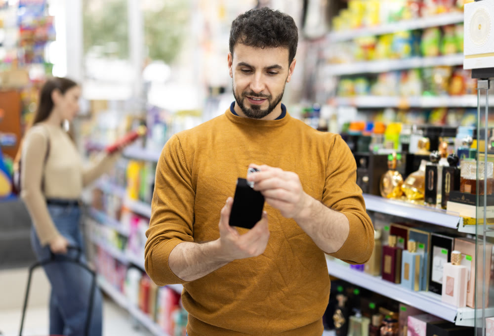 Young man chooses perfume in store