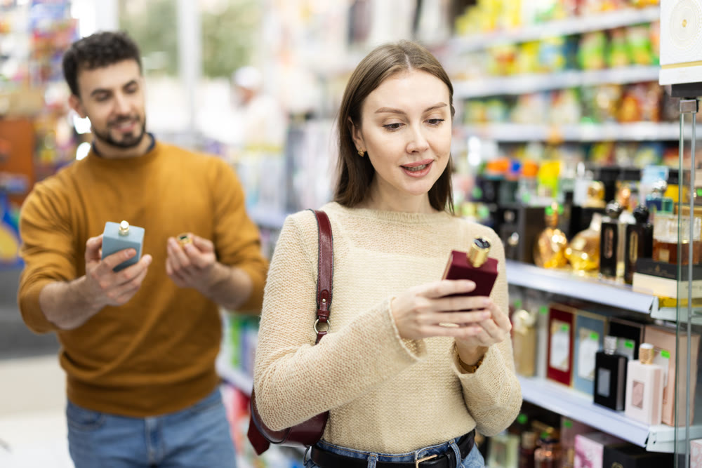Couple choosing bottle of perfume in perfume shop