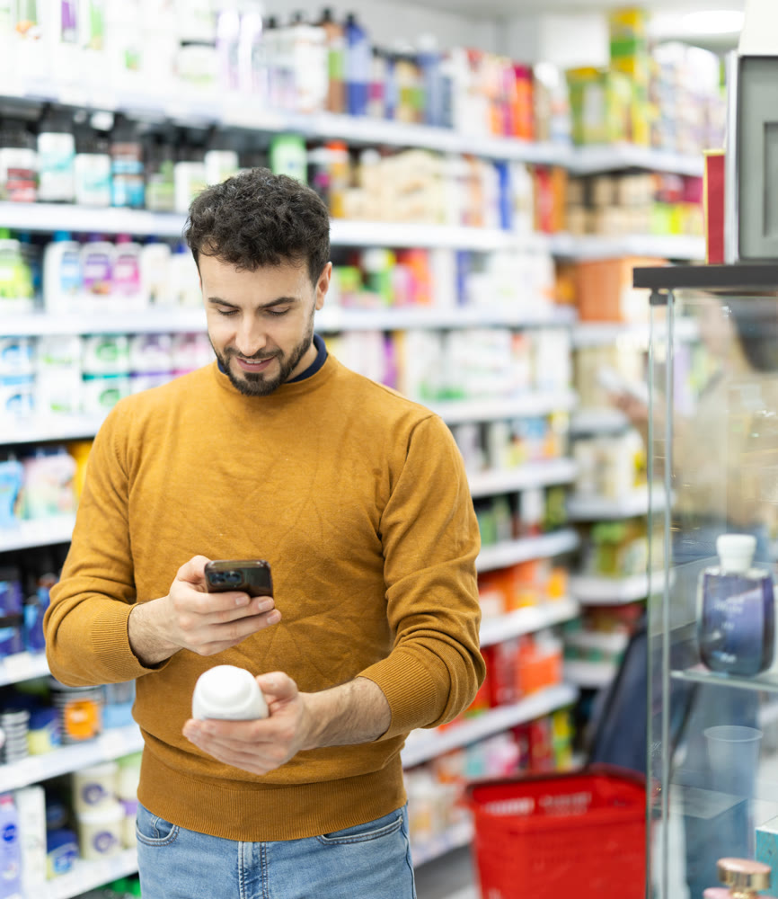 Young man scanning QR code on care products