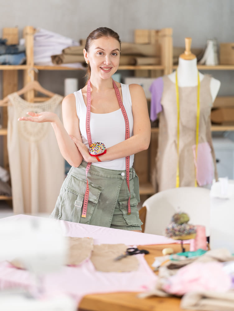 Young female dressmaker inviting clients to sewing workshop