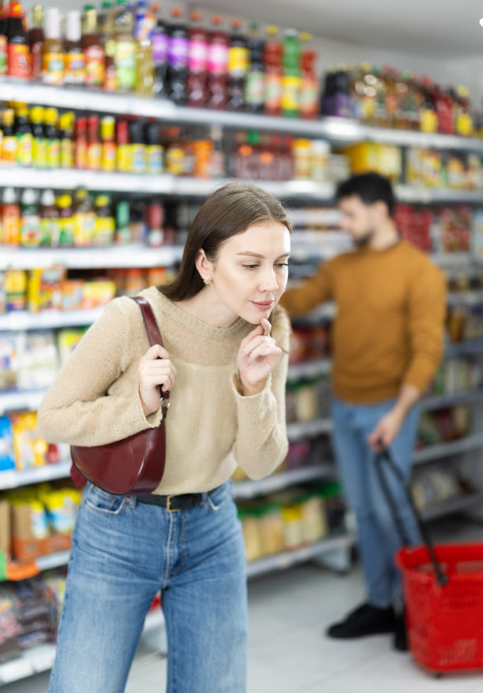 Young woman choosing food in grocery store