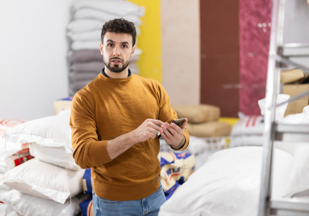 Man storekeeper keeps track of goods on the shelves of awarehouse or store