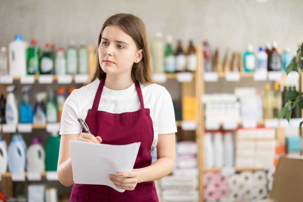 Young woman seller conducting inventory in store