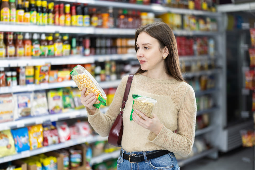 Young woman chooses beans at grocery store