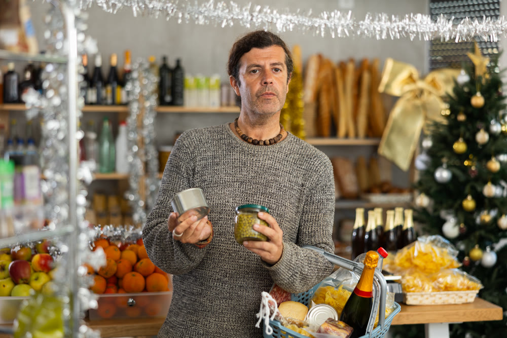 Shopper picking up reserved food while choosing snacks for Christmas festivities