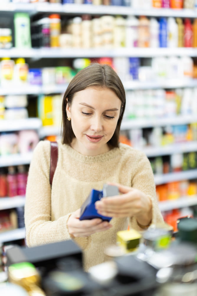 Young woman chooses perfume in store