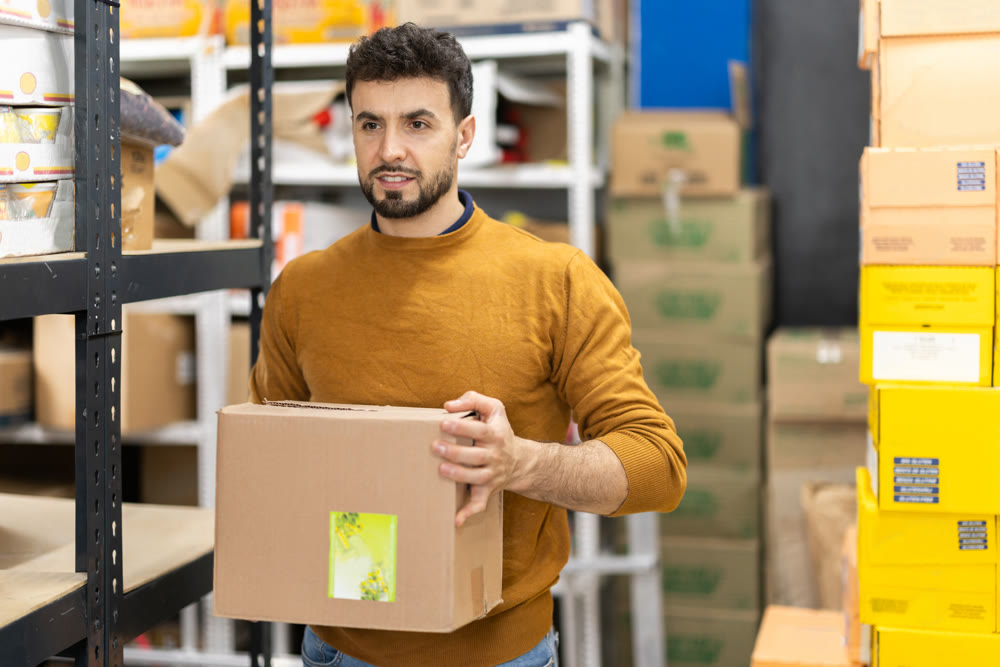 Worker loading box at warehouse store