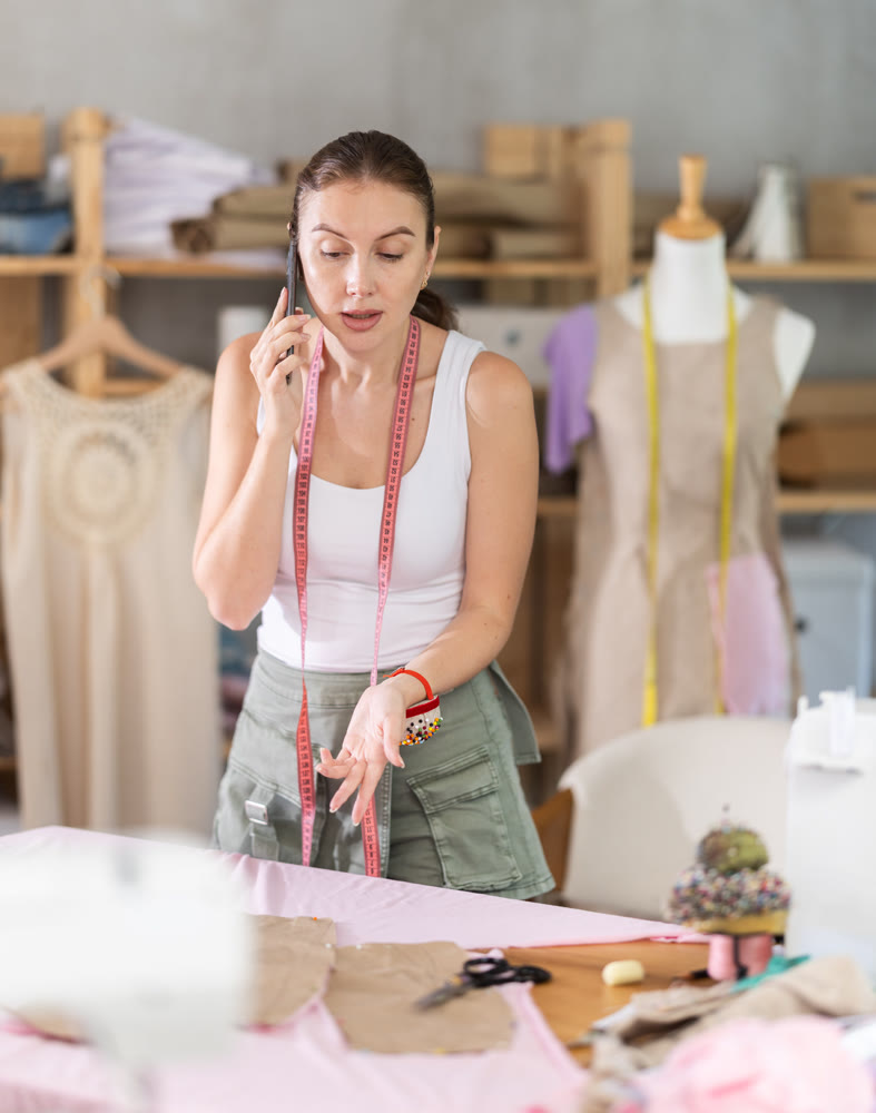 Angry seamstress is talking on phone