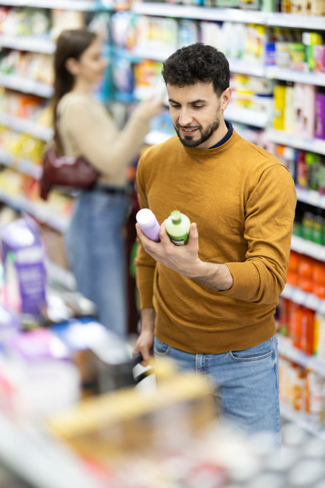 Male shopper is shopping in a supermarket, buying body care products