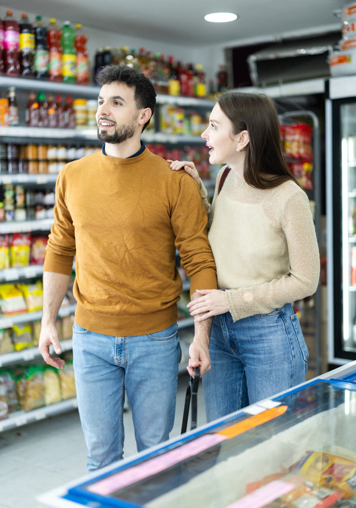 Couple of shoppers are choosing something in food store