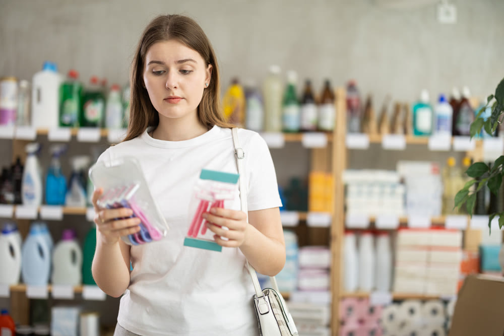 Young woman choosing razor in store