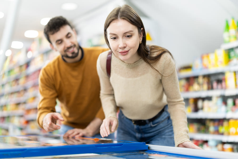 Couple spends time in store, looking for necessary goods and get out from refrigerator