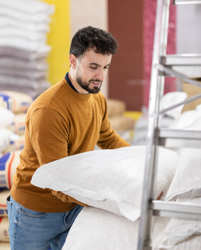 Man spends time in store, looking for goods and select pillow