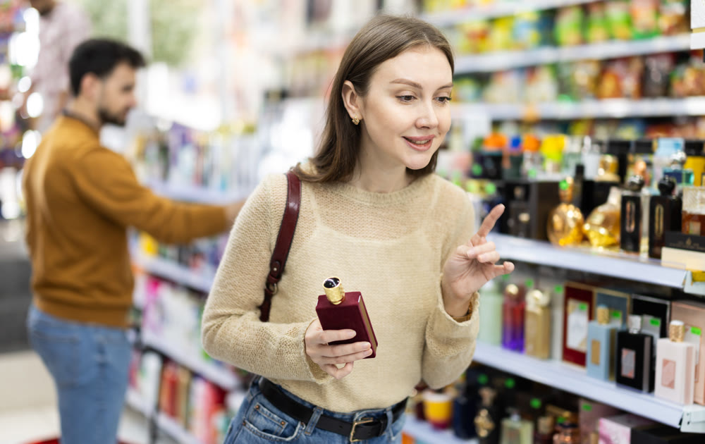 Young woman chooses perfume in store