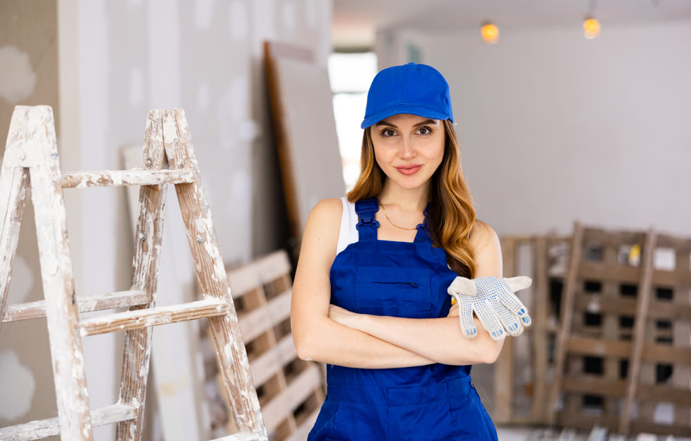 Portrait of positive woman builder during repair works