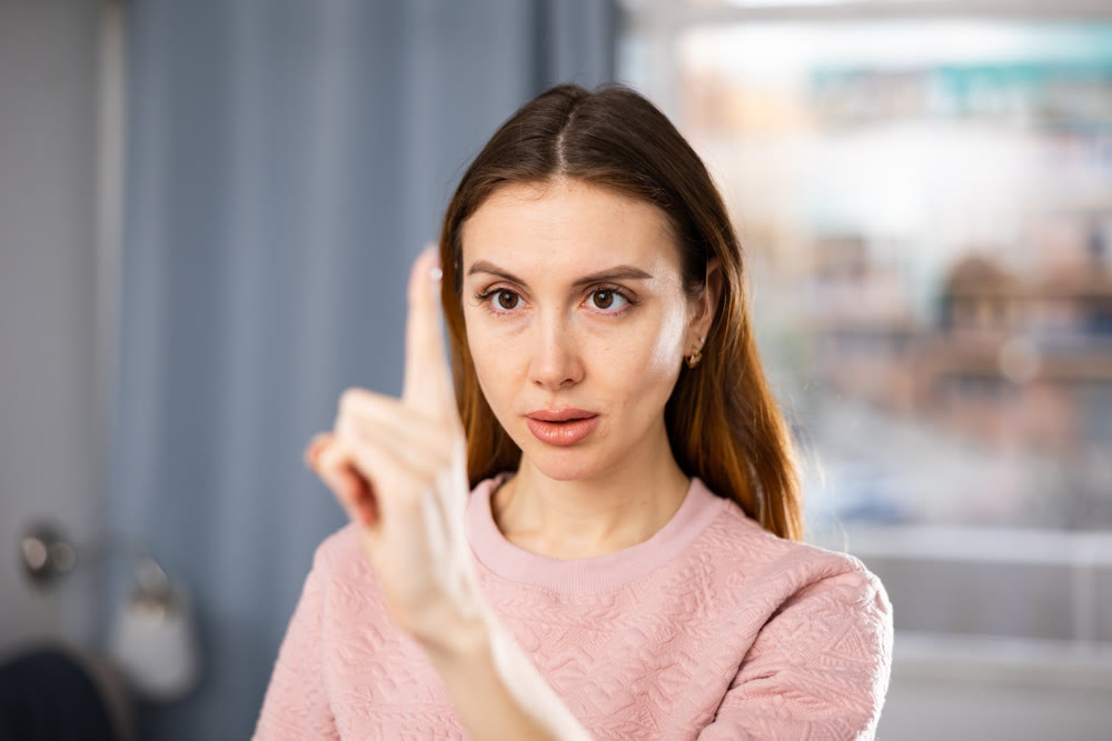 Girl checks her eyesight - carefully looks at her finger. Gymnastics for eyes