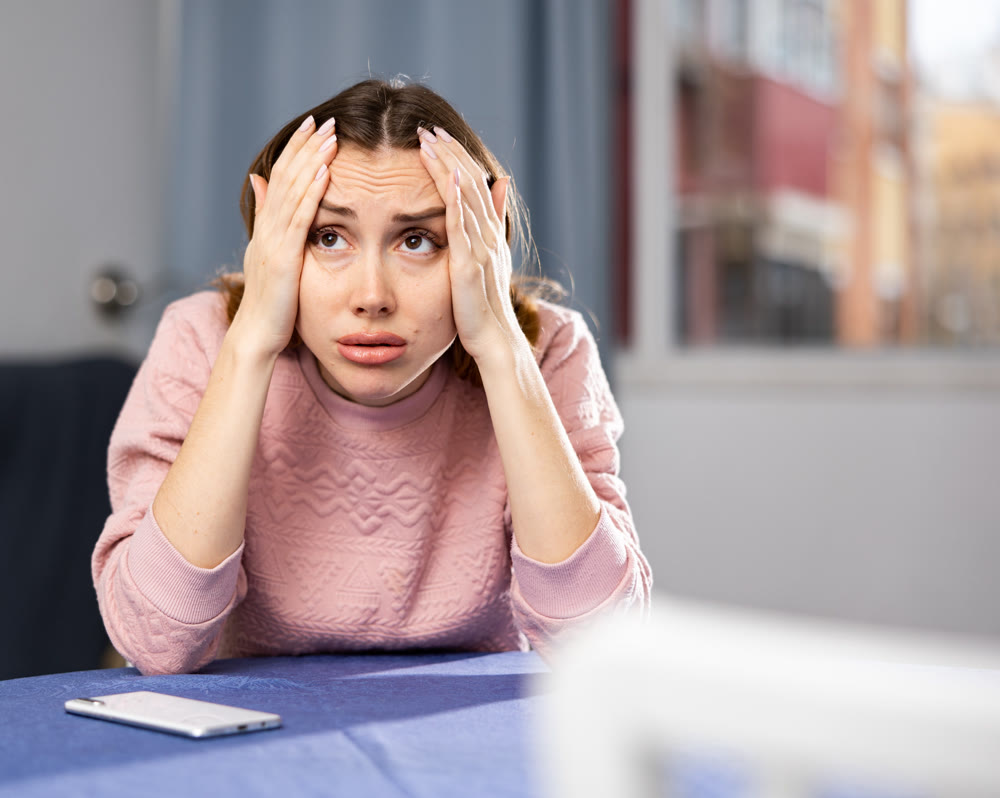 Portrait of a frustrated young woman sitting at a table