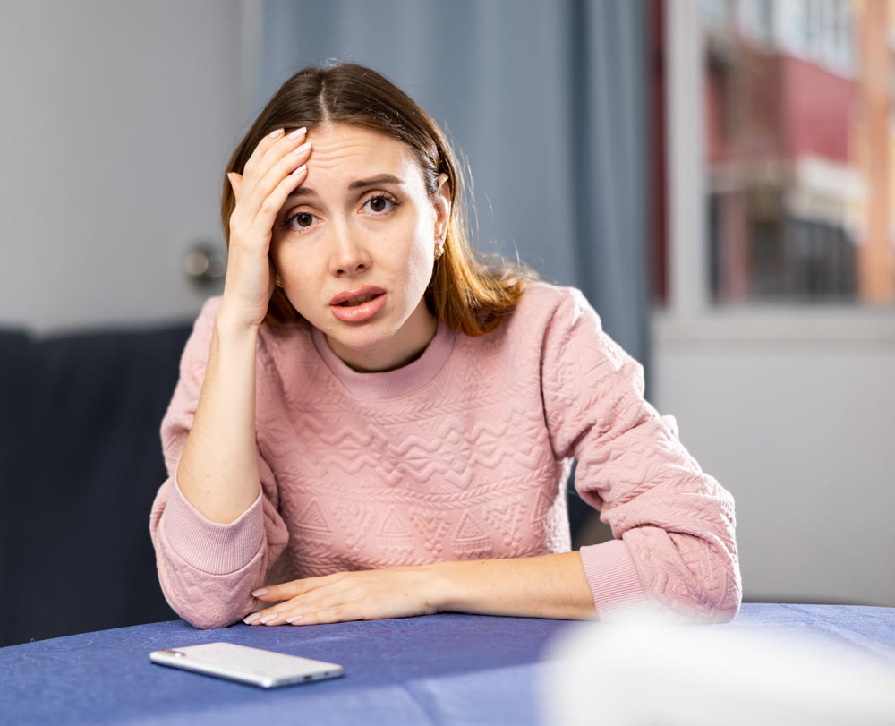 Portrait of a frustrated young woman sitting at a table