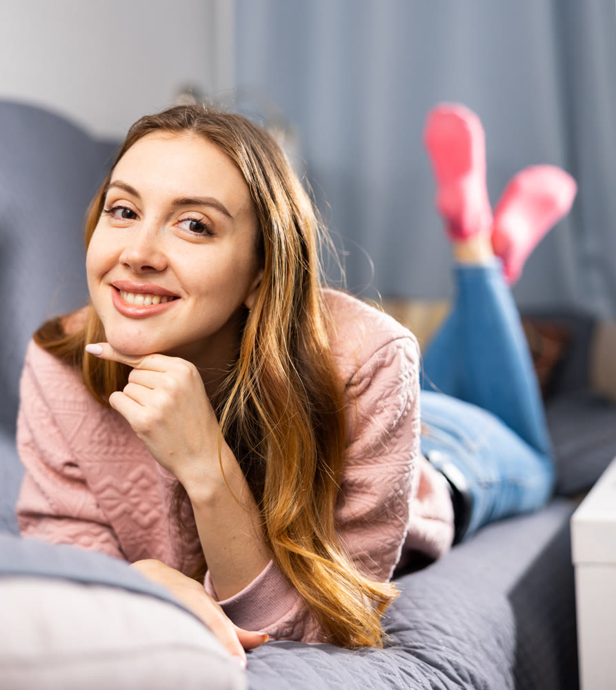 Portrait of a young woman lying on the sofa