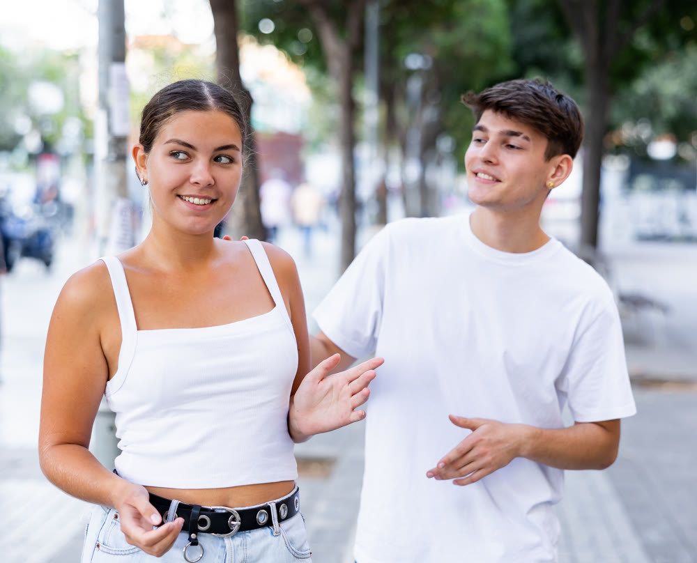 Young man trying to acquaint with girl outdoors