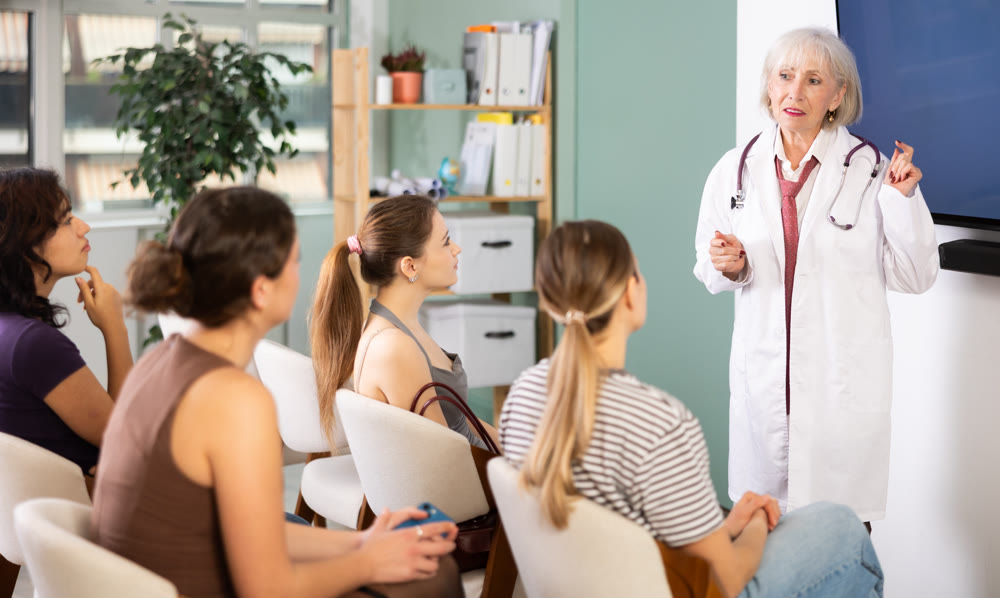Mature medical professor explaining presentation to female audience