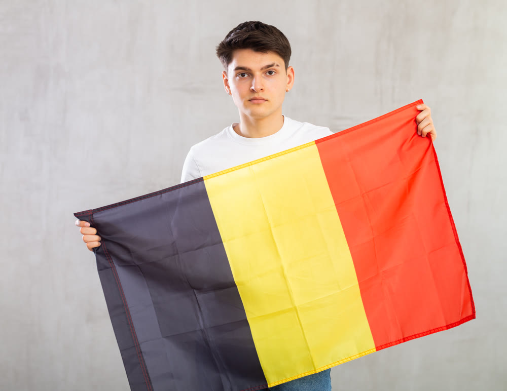 Portrait of young man of Belgium match waving national flag
