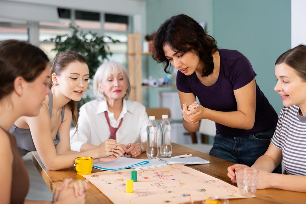 Group of women playing board game around a table