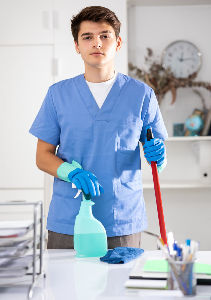 Portrait of positive male cleaner in protective uniform at company office