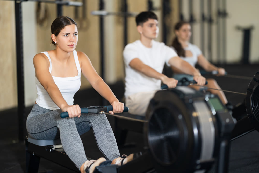 Young woman training her arms on machine