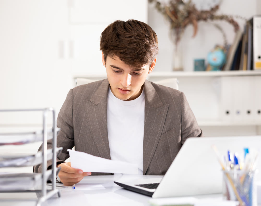 Businessman works in the office - puts documents in order and draws up contract
