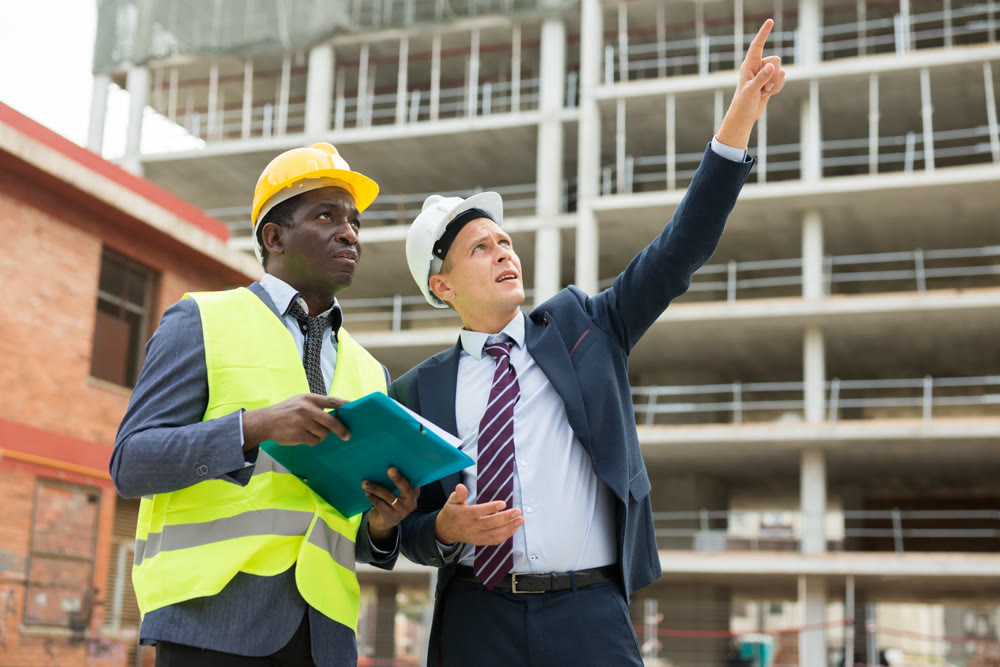 Young architect discusses a construction plan with an engineer