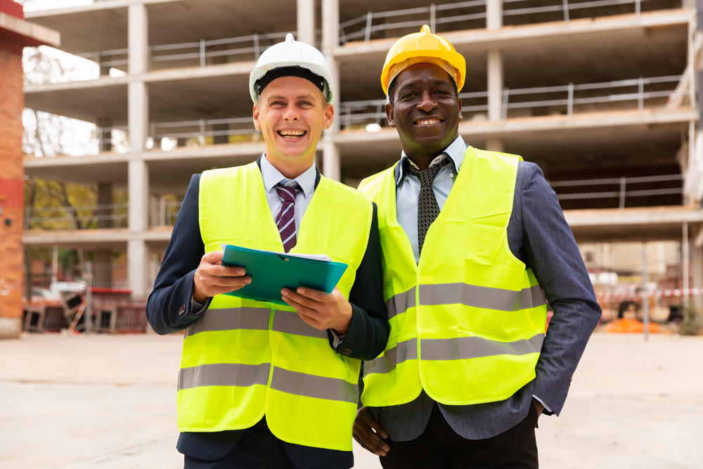 Positive builders standing on construction site