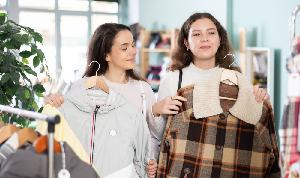 Two young women choosing coat and jacket