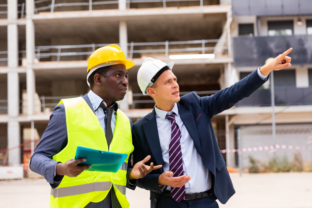 Young architect discusses a construction plan with an engineer