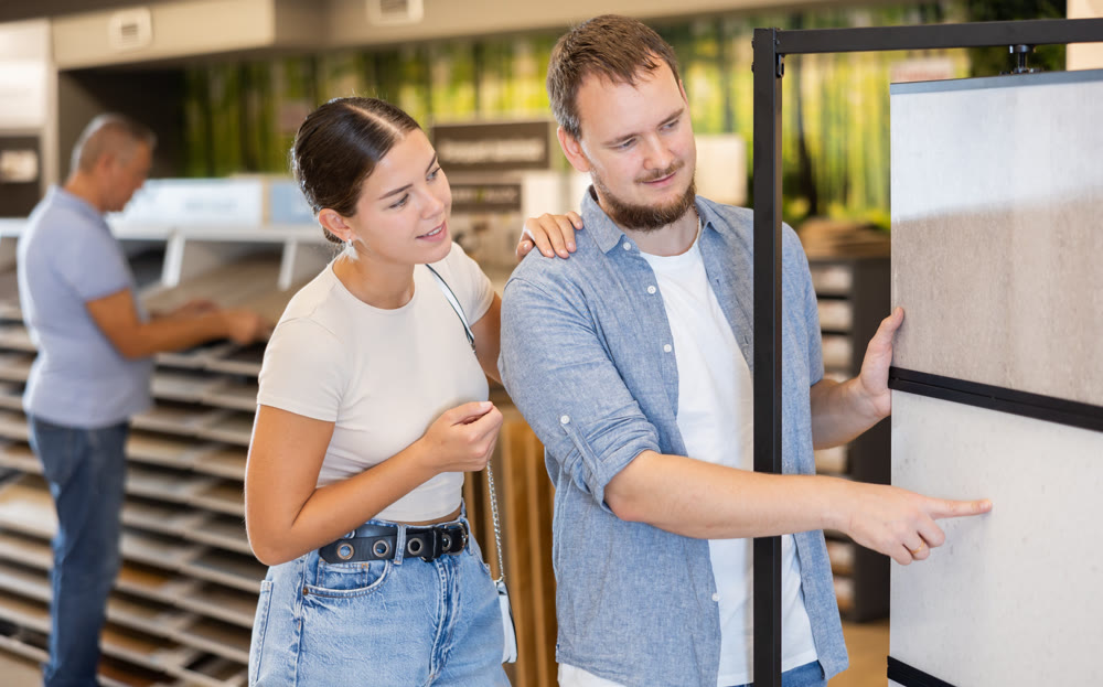 Married couple looking to buy floor tiles in materials section of hardware store