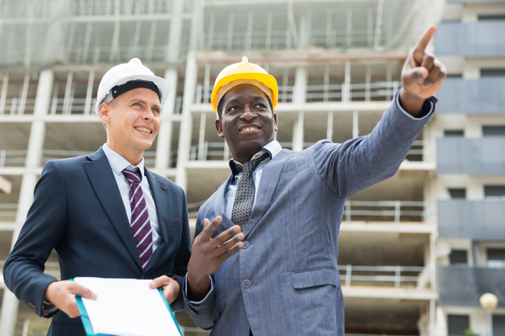 Architects talking about project documentation on construction plant