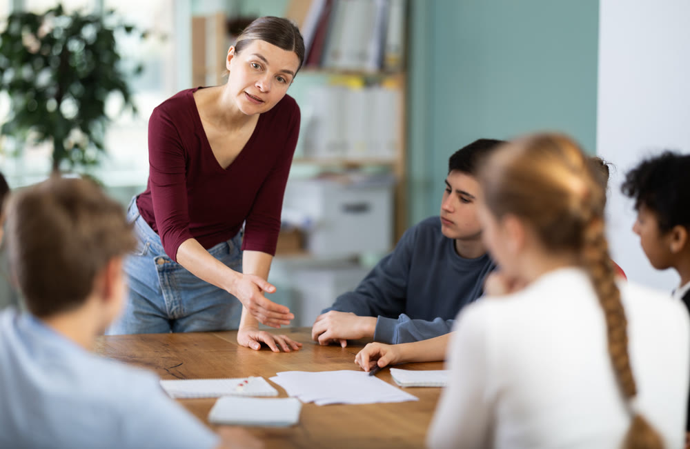 Female teacher gives a task to a group of schoolchildren
