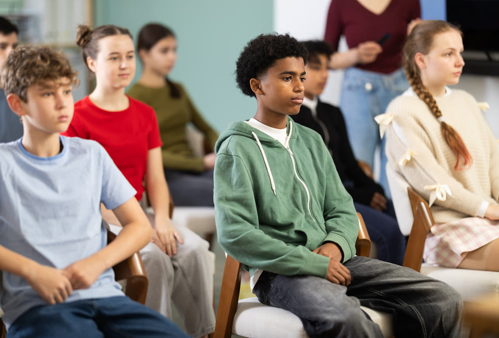 Teenage children sit in the classroom and look at the presentation