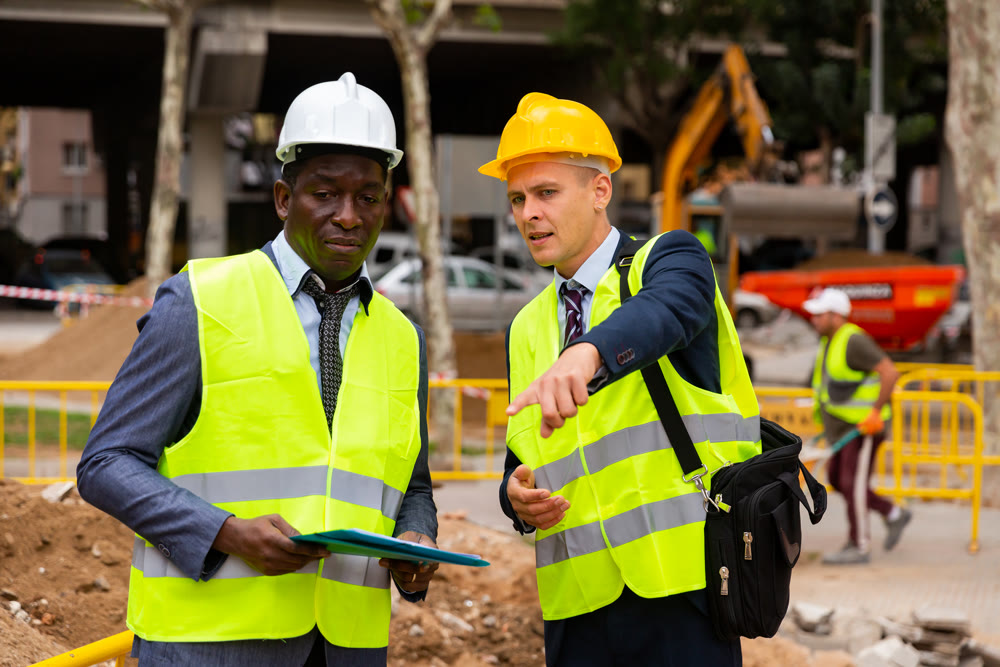 Young worker is discussing a project with a colleague, showing him something