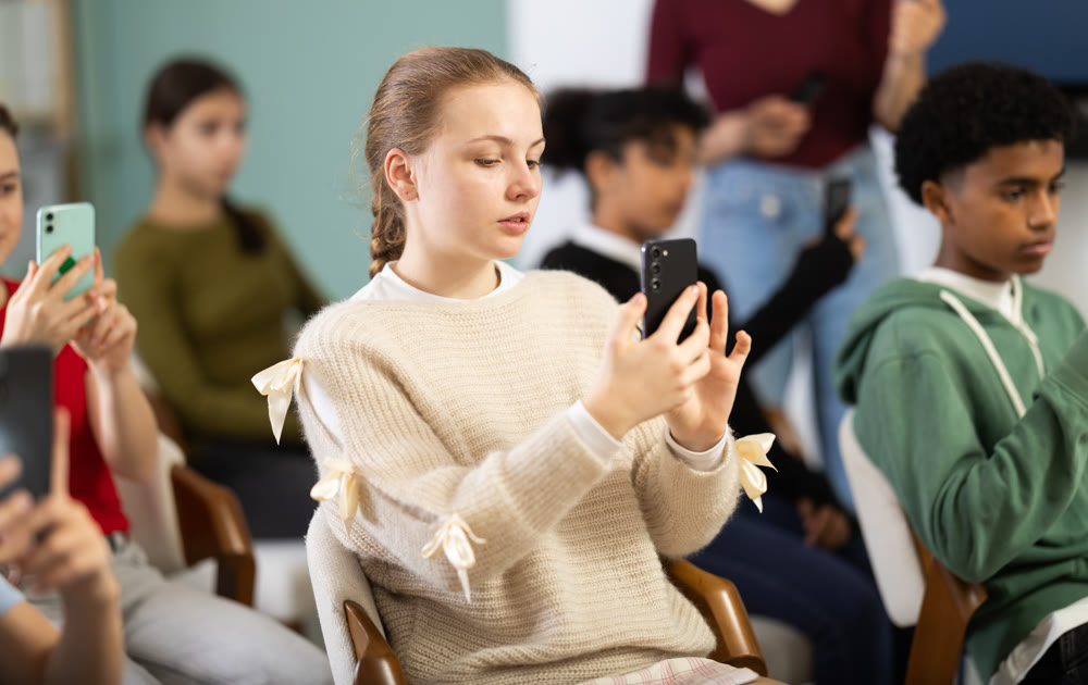 European teen girl scans a barcode on a mobile app to get more materials