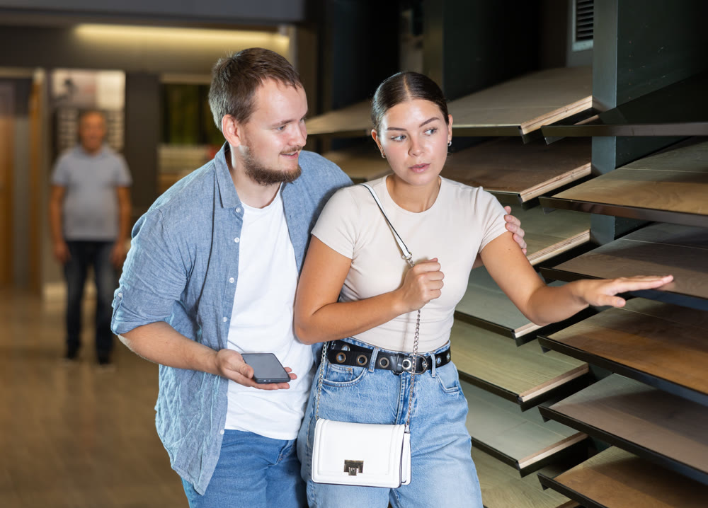 Couple man and woman choosing laminate sample