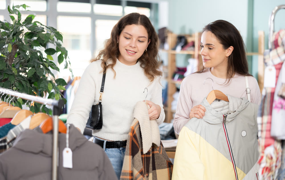 Two young women choosing coat and jacket