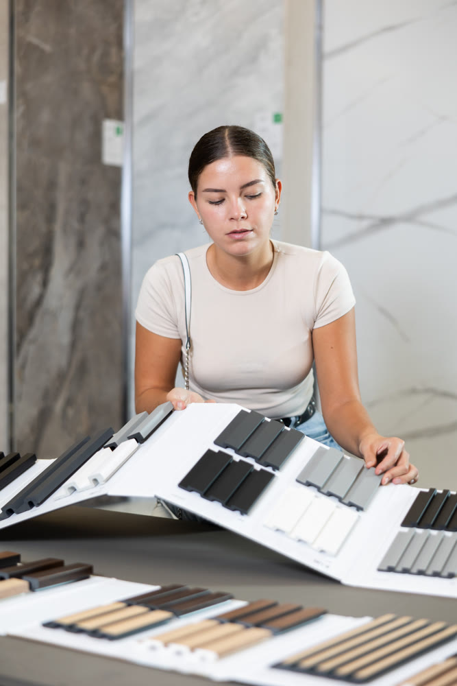 Woman chooses decorative wall or floor coverings for her home with interest