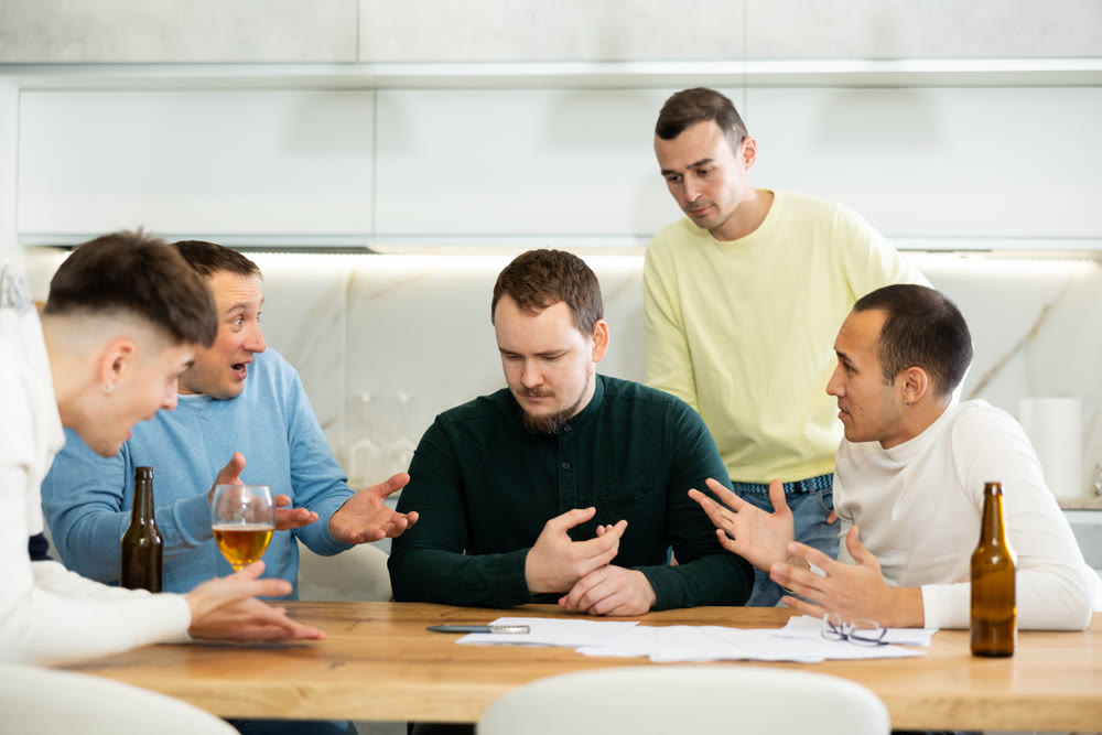 Friends comforting upset man receiving unpleasant news