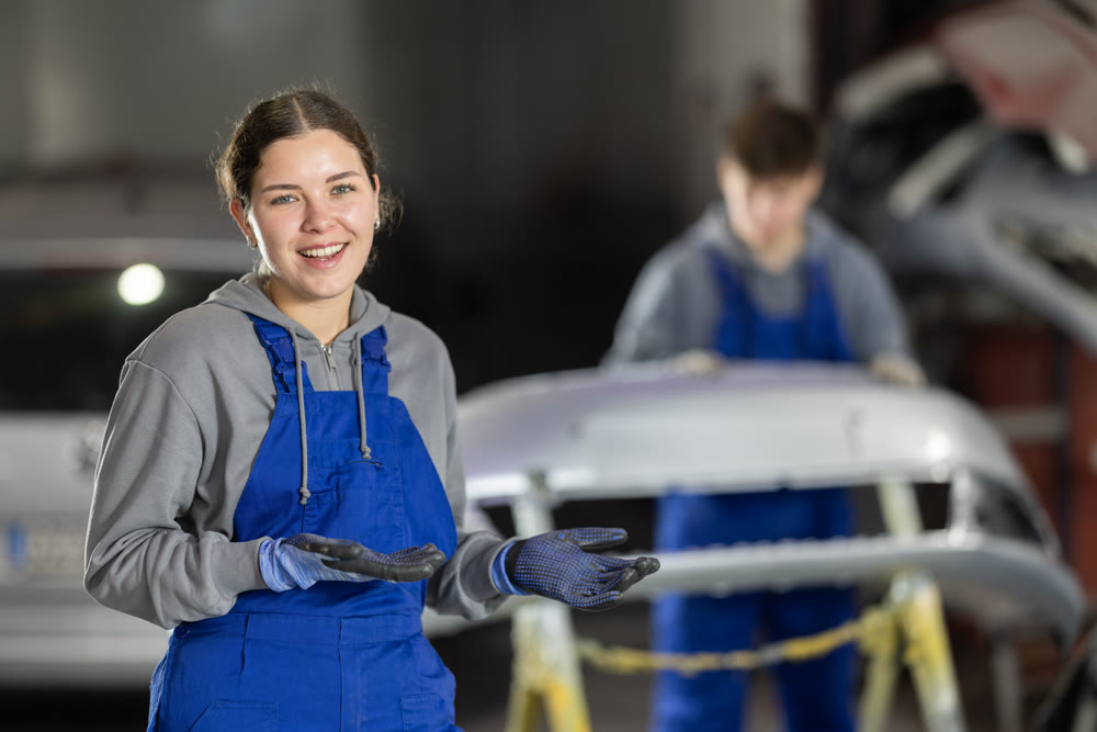 Service station young woman employee works in repair box, department