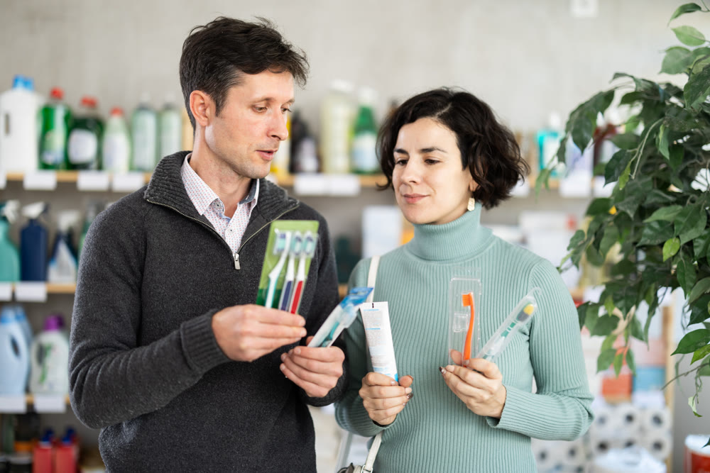Among shop windows, spouses buyers leisurely examines goods and chooses toothbrush