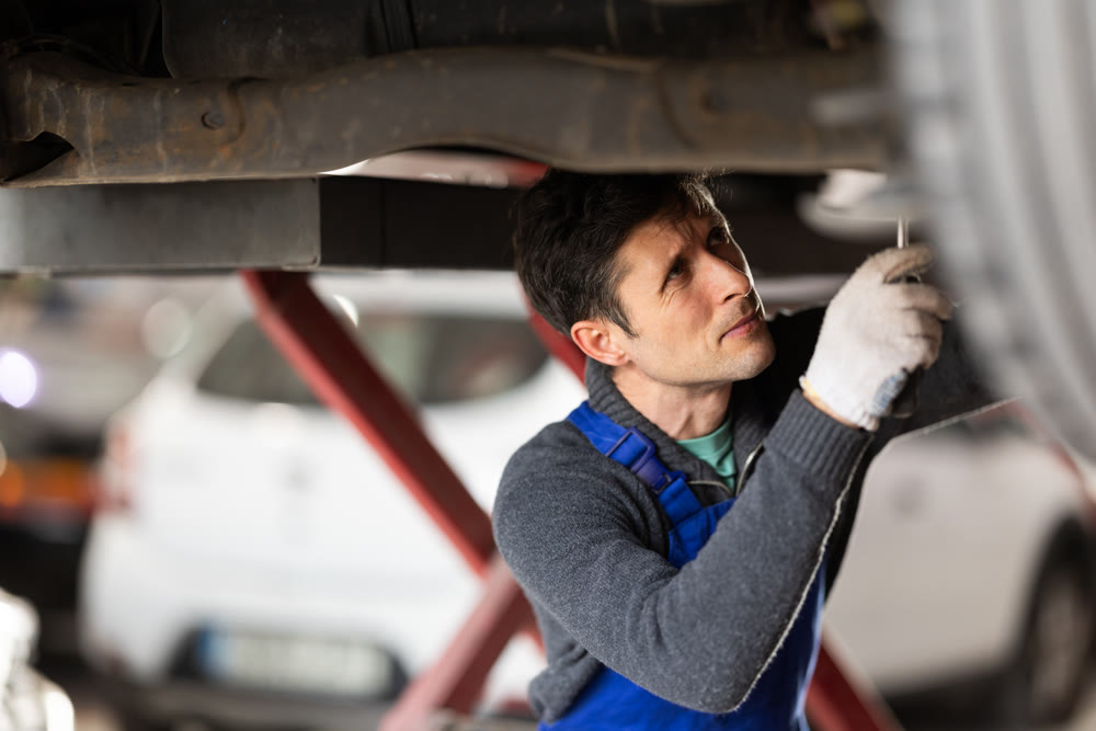 Service station man employee works in repair box, department